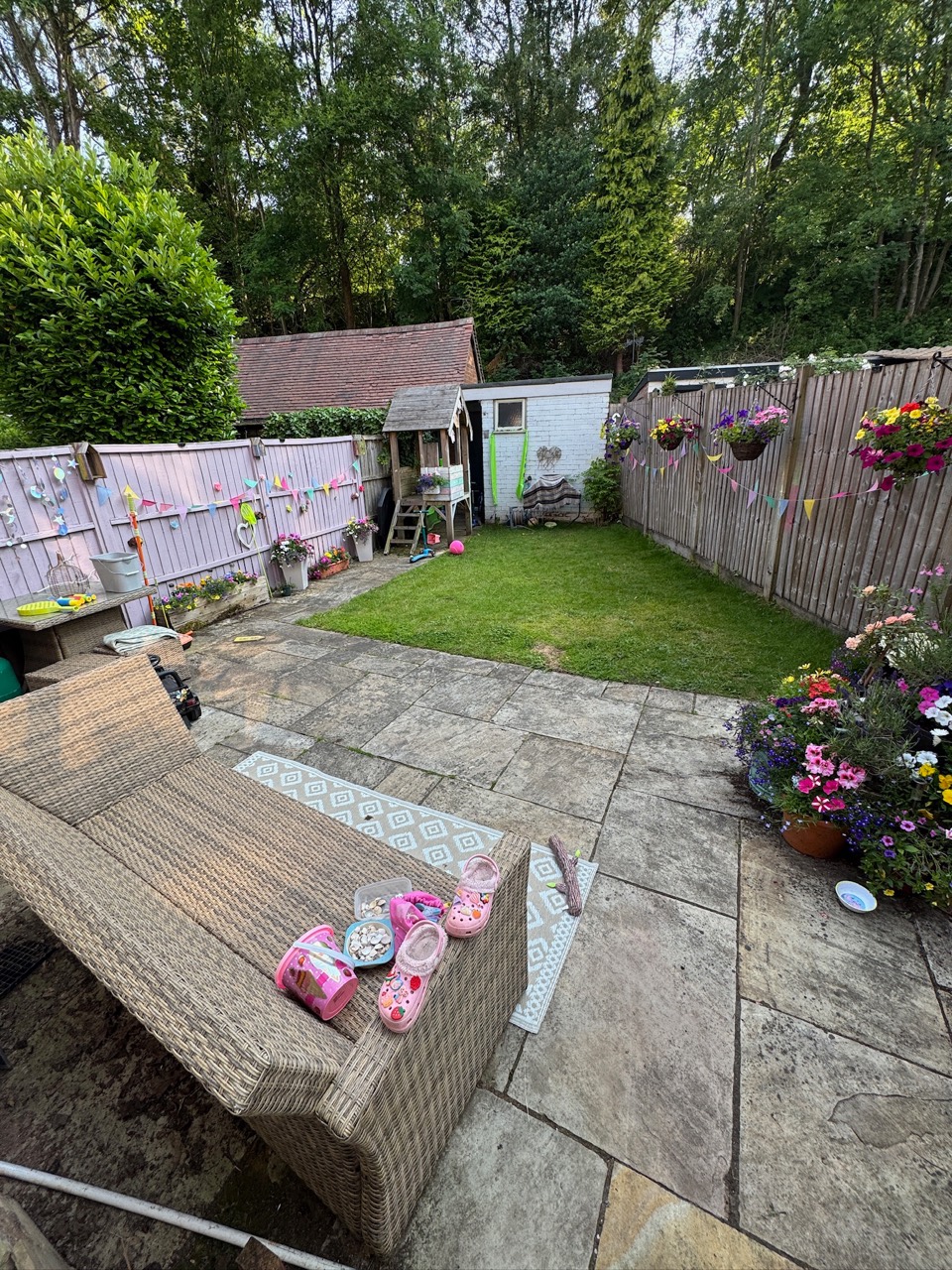 Before: older garden paving around a lawn and timber fences